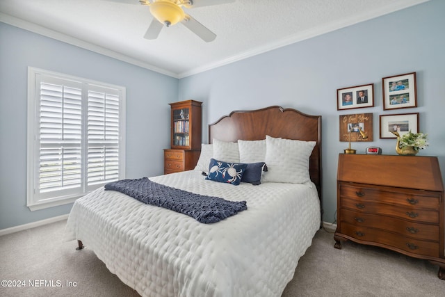 carpeted bedroom with ceiling fan, a textured ceiling, and crown molding