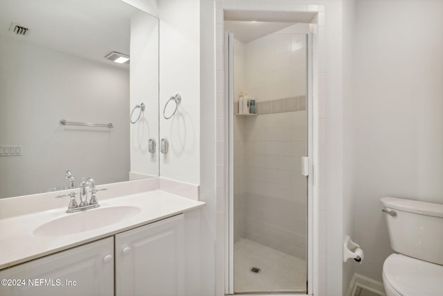 bathroom featuring vanity, toilet, and an enclosed shower