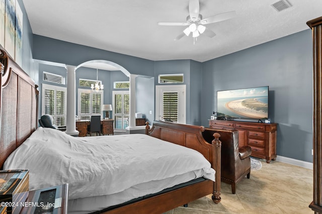 bedroom featuring ceiling fan with notable chandelier and decorative columns