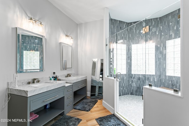 bathroom featuring hardwood / wood-style flooring, vanity, a shower with door, and tile walls