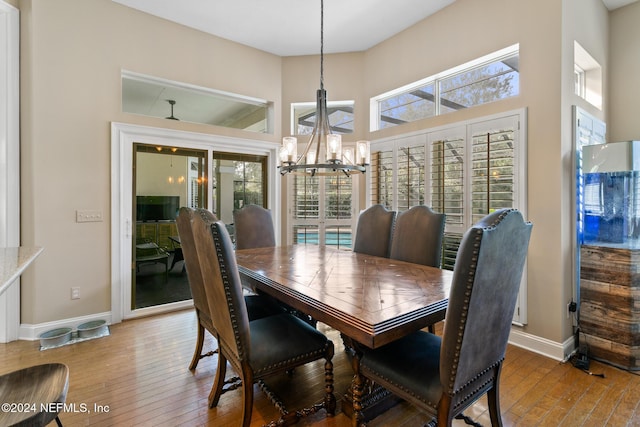 dining space with hardwood / wood-style floors and an inviting chandelier