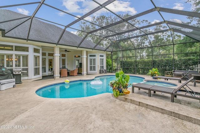 view of pool featuring glass enclosure, ceiling fan, an in ground hot tub, and a patio