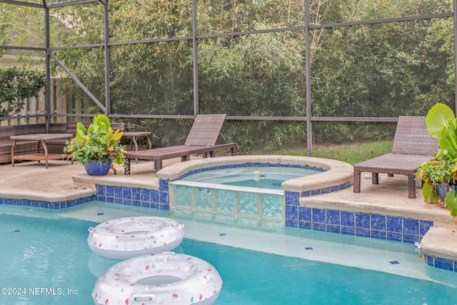 view of swimming pool with a patio area, an in ground hot tub, and glass enclosure