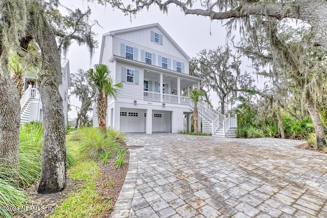 coastal inspired home featuring covered porch and a garage