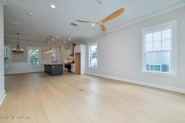 unfurnished living room with light hardwood / wood-style flooring, a wealth of natural light, and crown molding