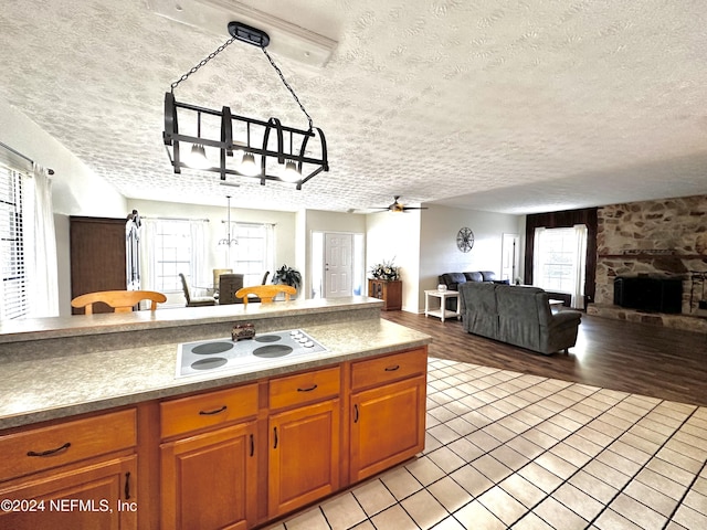 5609 County Road 352, Keystone Heights, FL 32656 - kitchen featuring white electric stovetop, open floor plan, a textured ceiling, brown cabinets, and a ceiling fan