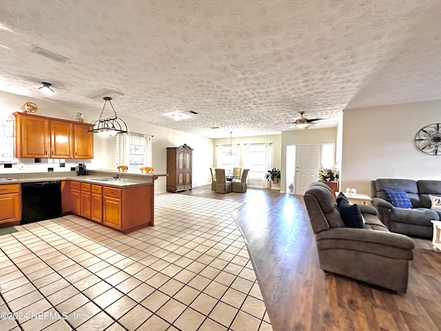 5609 County Road 352, Keystone Heights, FL 32656 - kitchen featuring black dishwasher, open floor plan, a peninsula, a textured ceiling, and a sink