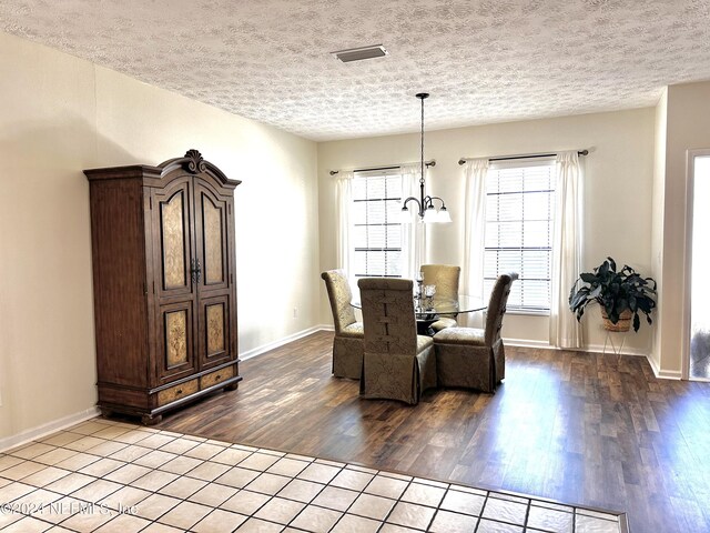 5609 County Road 352, Keystone Heights, FL 32656 - dining space featuring wood finished floors, a textured ceiling, a chandelier, and baseboards
