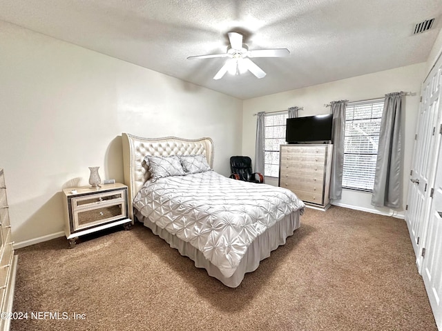 carpeted bedroom featuring a textured ceiling and ceiling fan