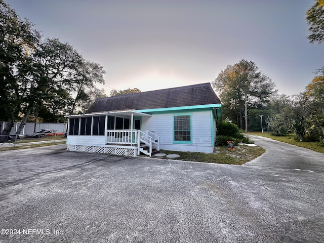 5609 County Road 352, Keystone Heights, FL 32656 - view of front of house with a sunroom, roof with shingles, and fence
