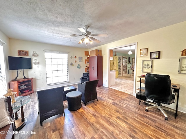 office space with a textured ceiling, wood-type flooring, and ceiling fan