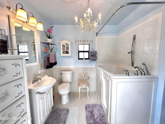 bathroom with a bath, toilet, tile walls, tile patterned floors, and vanity