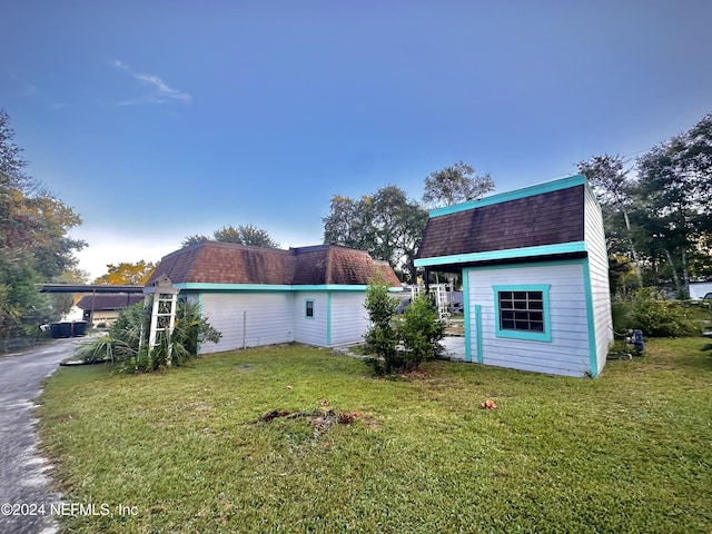 5609 County Road 352, Keystone Heights, FL 32656 - view of side of property featuring an outdoor structure, a lawn, and a shingled roof