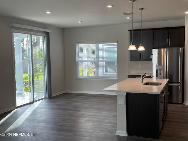 kitchen featuring a healthy amount of sunlight, an island with sink, and pendant lighting