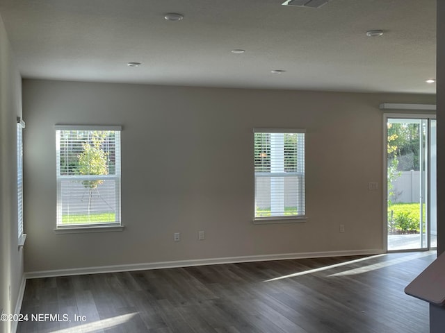 unfurnished room with dark hardwood / wood-style flooring