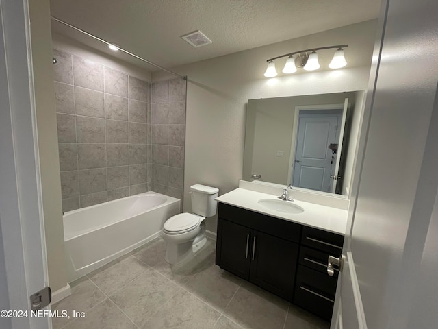 full bathroom with tiled shower / bath combo, tile patterned flooring, a textured ceiling, toilet, and vanity