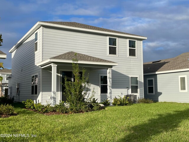 back of property featuring a lawn