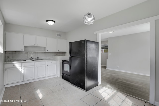 kitchen featuring decorative backsplash, white cabinets, light hardwood / wood-style flooring, black appliances, and decorative light fixtures