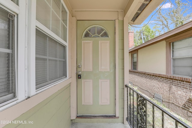 view of exterior entry featuring a balcony