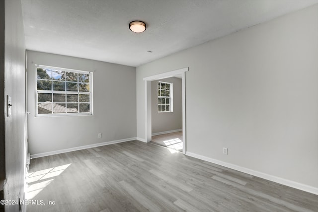 spare room with light hardwood / wood-style flooring and a textured ceiling