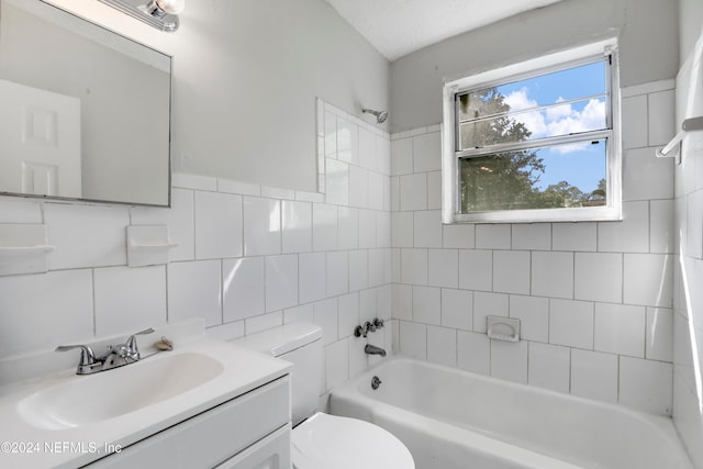 full bathroom featuring vanity, toilet, tile walls, and tiled shower / bath