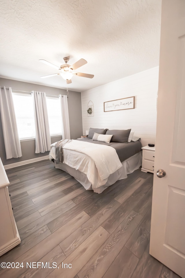 bedroom featuring a textured ceiling, ceiling fan, and dark hardwood / wood-style floors