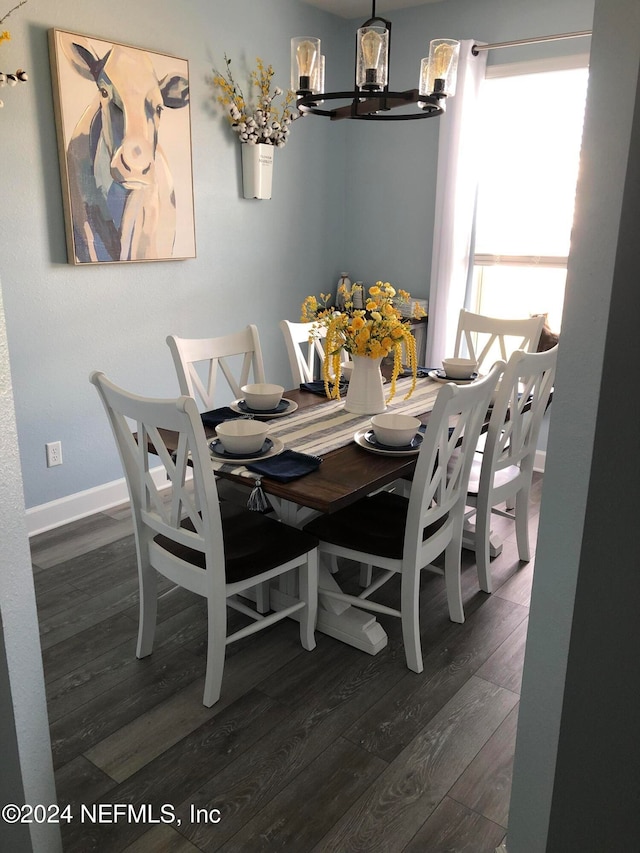 dining area with dark hardwood / wood-style floors and a chandelier