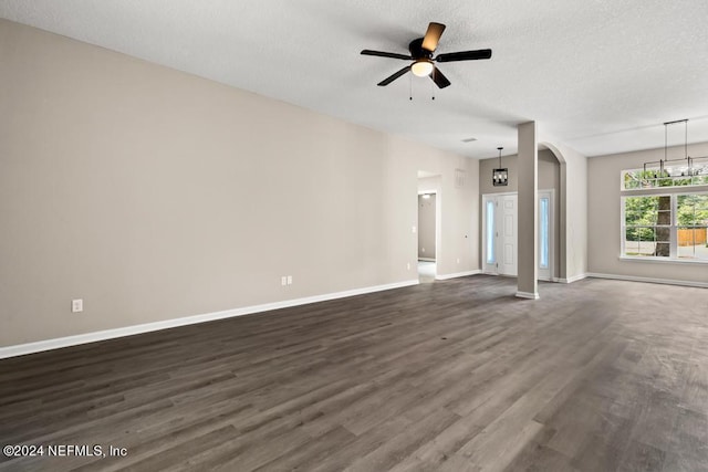 unfurnished living room featuring a textured ceiling, dark hardwood / wood-style floors, and ceiling fan with notable chandelier