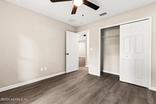 unfurnished bedroom featuring dark wood-type flooring, a closet, and ceiling fan