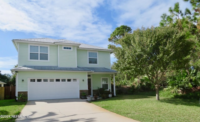 view of front of property featuring metal roof, a front lawn, a standing seam roof, driveway, and an attached garage