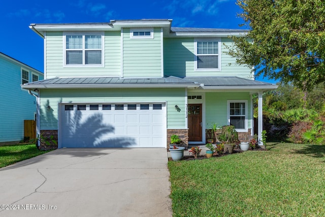 view of front of house featuring a porch, concrete driveway, a front yard, a standing seam roof, and a garage