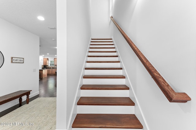 stairway featuring recessed lighting and wood finished floors