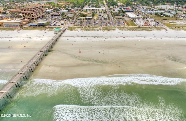 birds eye view of property featuring a view of city, a water view, and a beach view