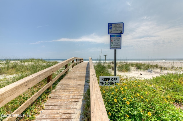 view of community featuring a beach view and a water view