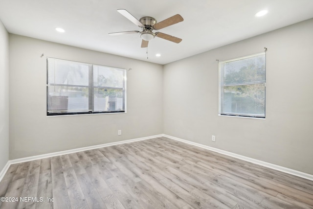 unfurnished room with a wealth of natural light, ceiling fan, and light hardwood / wood-style flooring