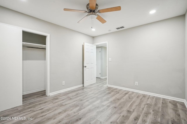 unfurnished bedroom featuring light hardwood / wood-style flooring, ceiling fan, and a closet