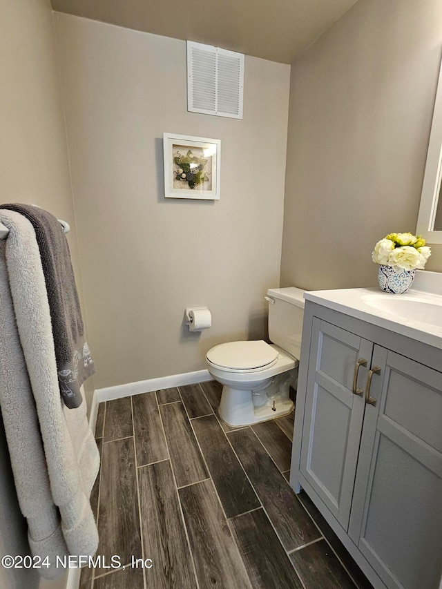 bathroom featuring vanity, hardwood / wood-style floors, and toilet