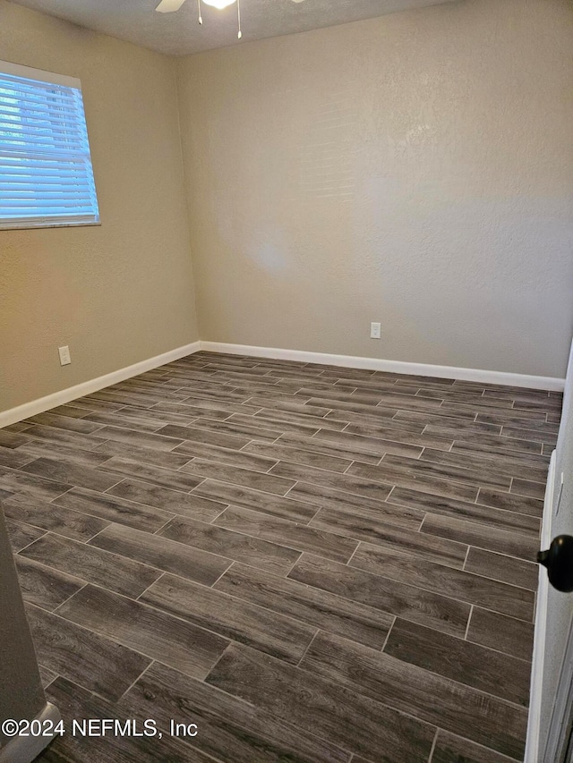 empty room featuring ceiling fan and dark hardwood / wood-style flooring