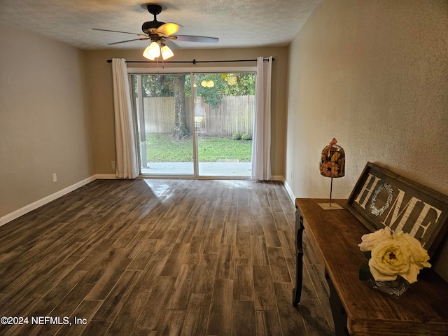 unfurnished living room with dark wood-type flooring, a textured ceiling, and ceiling fan