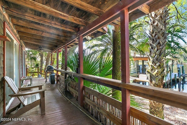 wooden terrace with a water view and a boat dock