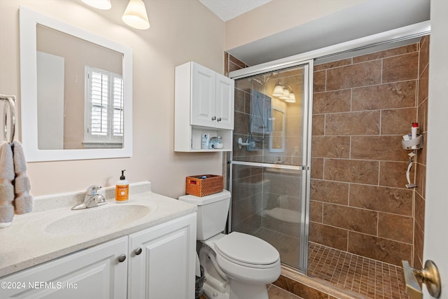 bathroom featuring vanity, toilet, and a shower with shower door