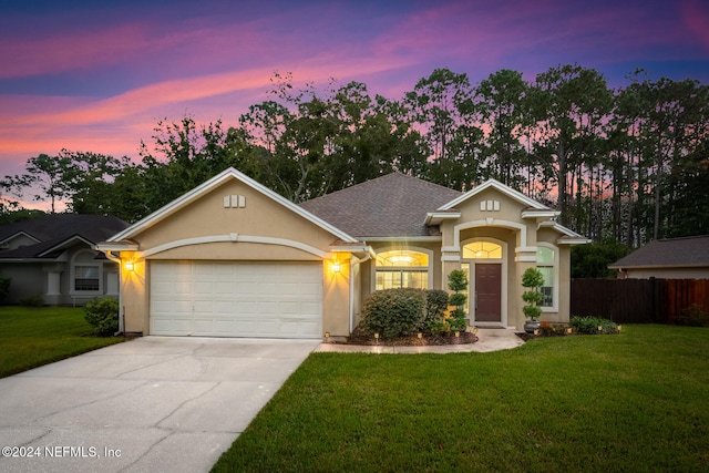 single story home featuring a lawn and a garage