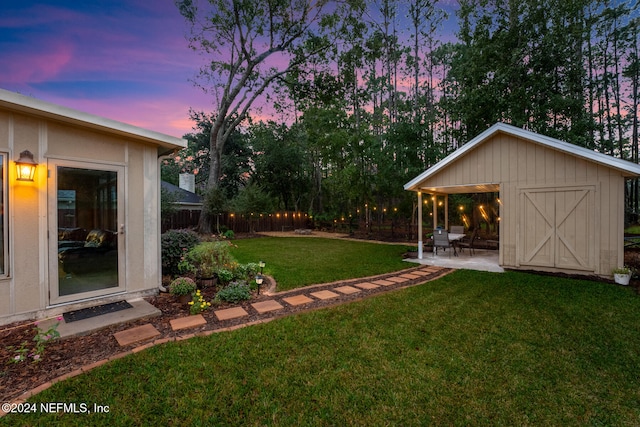 yard at dusk featuring a patio area and a shed