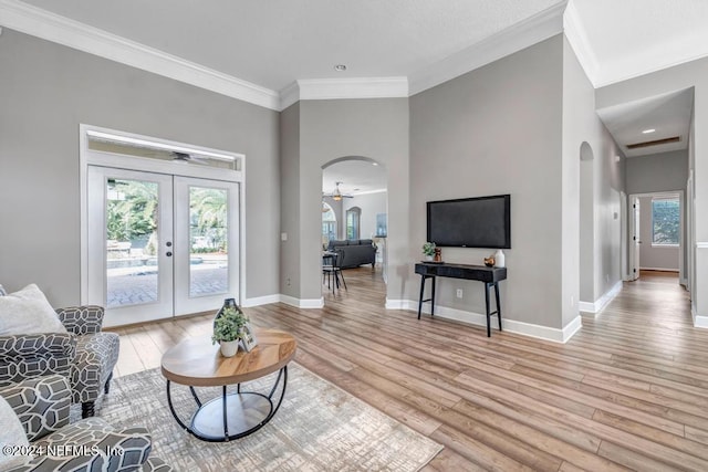 living room featuring ornamental molding, light hardwood / wood-style flooring, french doors, and ceiling fan