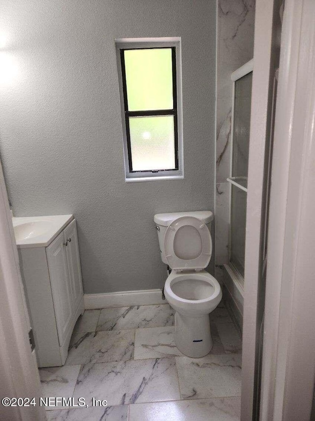 bathroom featuring vanity, toilet, and walk in shower