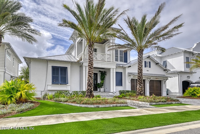 view of front of property with a garage, a balcony, and a front lawn