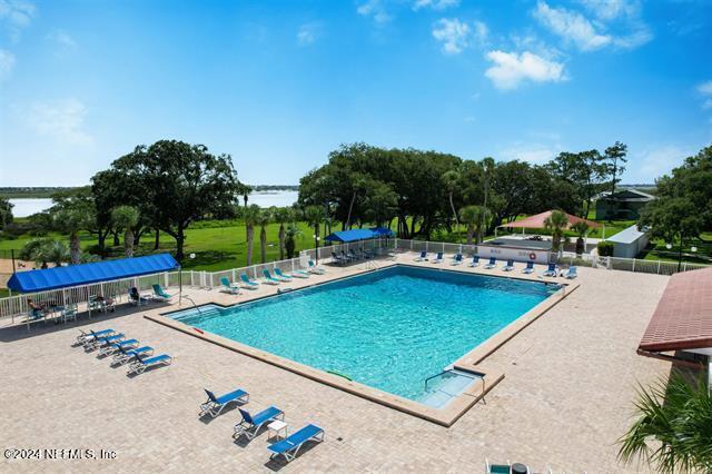 view of swimming pool with a patio and a water view