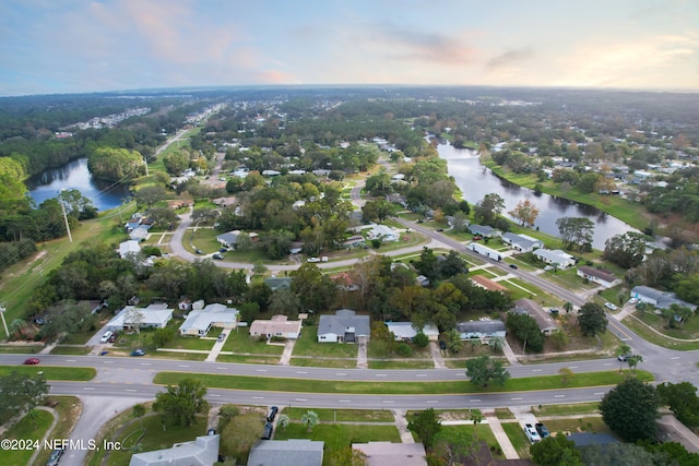 aerial view at dusk featuring a water view