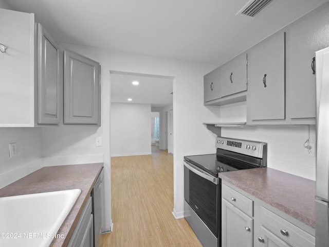 kitchen with sink, appliances with stainless steel finishes, light hardwood / wood-style flooring, and gray cabinets