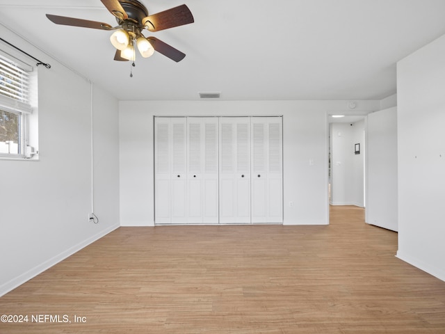 unfurnished bedroom featuring light hardwood / wood-style floors, a closet, and ceiling fan